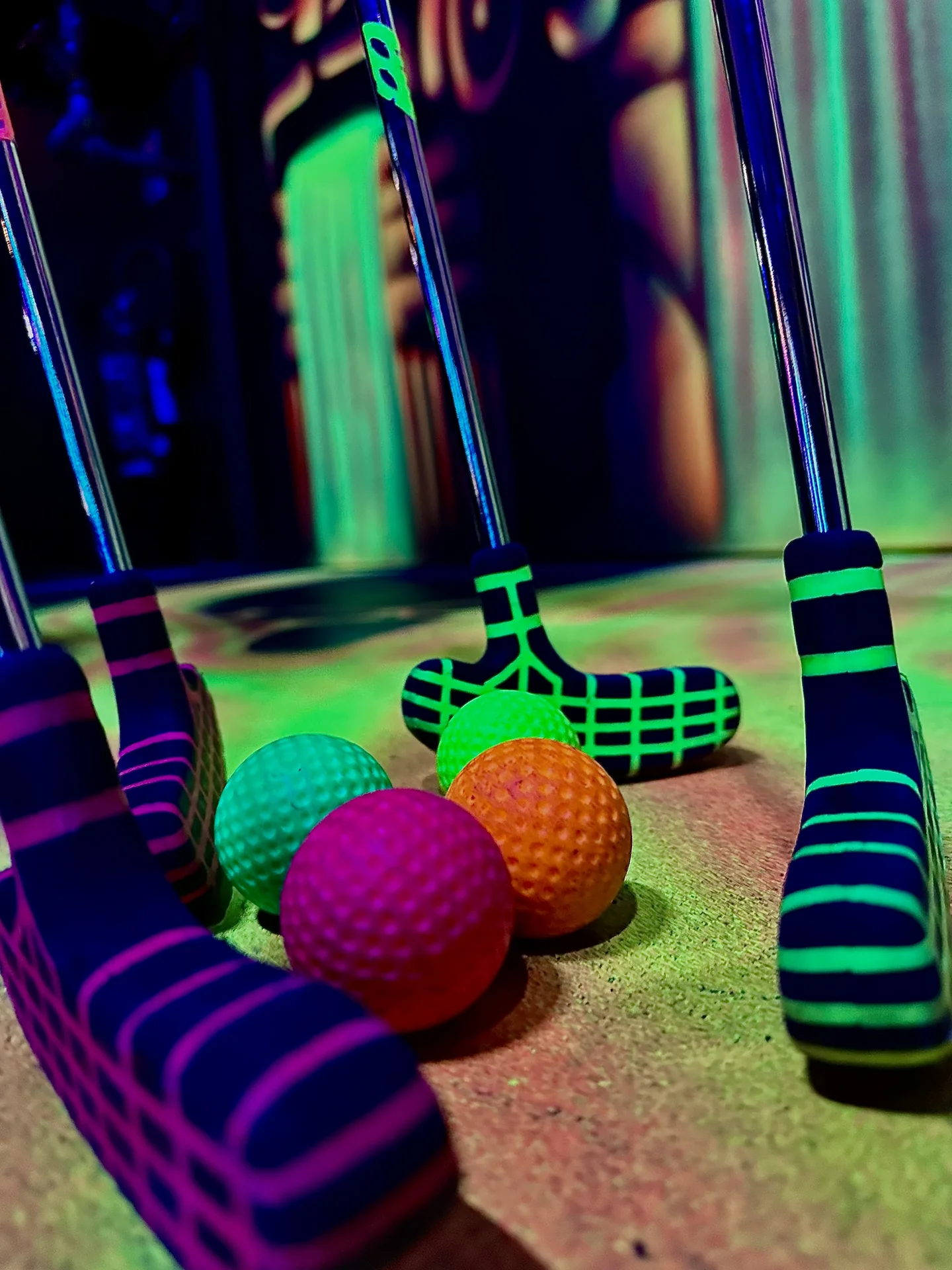 Clubs de mini-golf et balles colorées fluorescentes sur le parcours de Black Holes Minigolf à Chambly